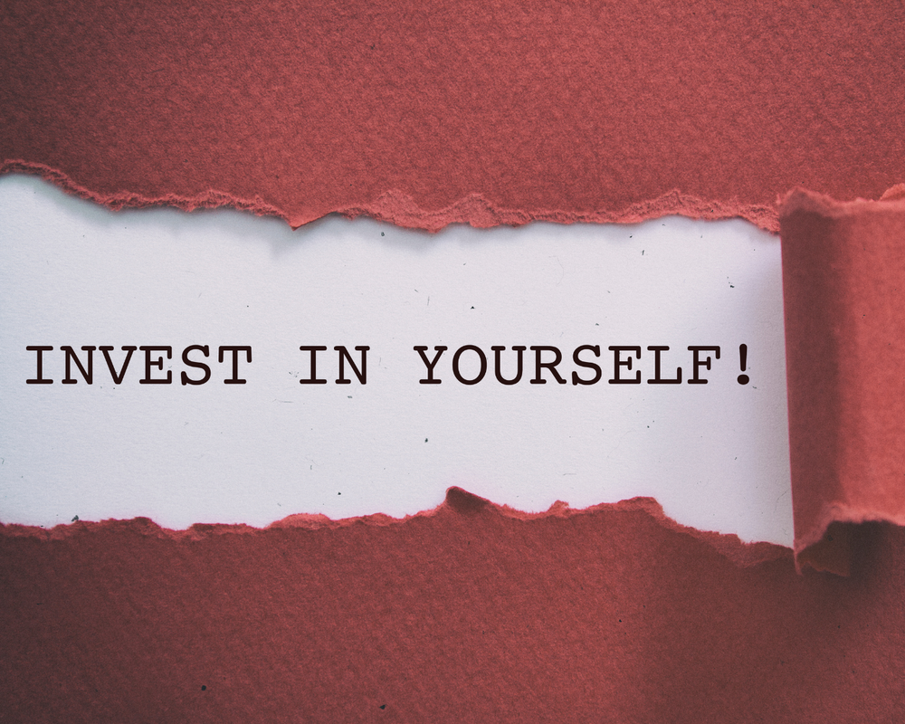 um papel escrito: "Invest in yourself!"