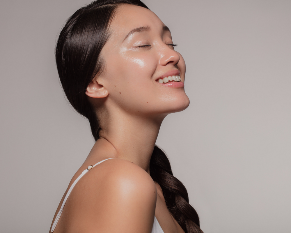 Fonte: Canva uma mulher branca de olhos fechados sorrindo